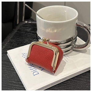 Macro view of a red lychee texture leather mini coin purse with golden metal clasp