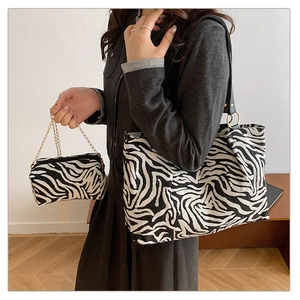 Detail of zebra print tote bag and matching mini pouch with gold metal chain
