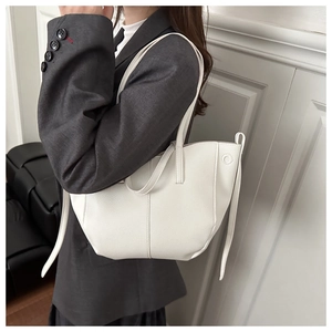Gros plan sur la texture en cuir blanc à motif litchi de ce grand sac fourre-tout