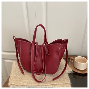 Close-up of wine red lychee leather tote bag with white contrast stitching details