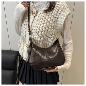Detailed view of vintage dark brown crescent bag with polished oil wax leather texture