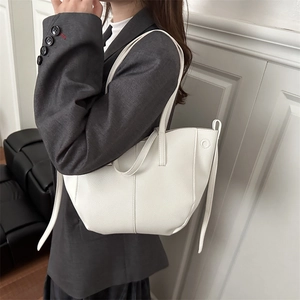 Minimalist white leather tote bag with vertical stitching and chic long side ribbons