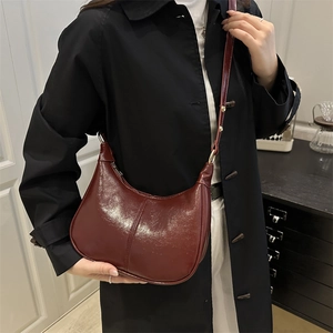 Minimalist burgundy half-moon crossbody bag in glossy faux leather for women