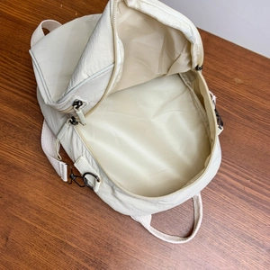 Dettaglio dello zaino in nylon crema con focus sullo scomparto interno spazioso