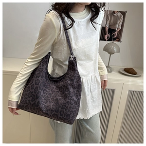 Detailed close-up of large leopard print hobo bag in a modern minimalist setting