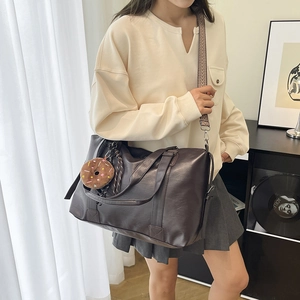 Minimalist large brown tote bag with woven strap and plush charm for daily commute