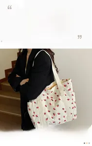 Detail of strawberry print corduroy tote bag featuring large capacity and side pocket