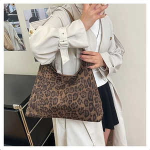 Detailed view of large leopard print hobo bag worn with beige trench coat for autumn style