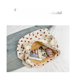 Detail showing high-capacity interior of strawberry corduroy tote with daily essentials