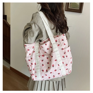 Pink corduroy tote bag with strawberry print and durable canvas straps side view