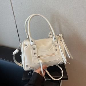 Sac Boston en cuir verni blanc avec clous argentés et longues franges à la poignée