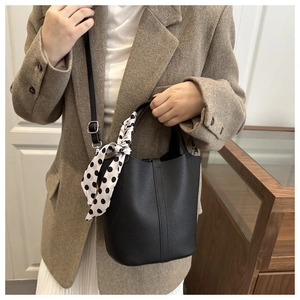 Black pebble leather bucket bag detail with polka dot scarf and silver hardware