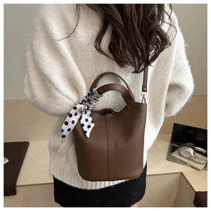 Brown lychee-grain leather bucket bag with decorative polka-dot silk scarf