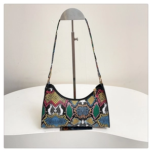 Close-up of colorful snake pattern texture and gold zipper on a chic crossbody bag