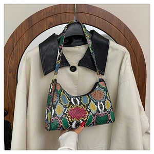 Detail of colorful snakeskin texture and crescent shape on a vintage shoulder bag