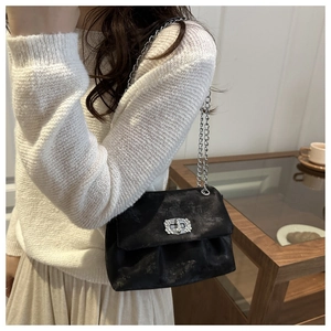 Détail du sac en velours noir avec fermoir diamanté argenté et bandoulière chaîne