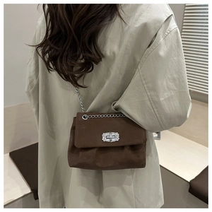 Détail du sac bandoulière en daim marron foncé avec boucle cristal et chaîne argent
