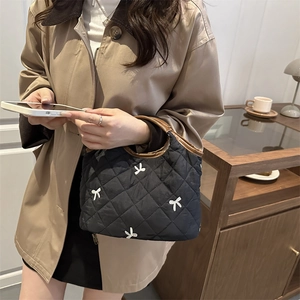 Quilted black handbag with white bow embroidery and brown leather handles for women