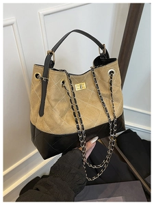 Détails du sac matelassé bicolore avec fermoir rotatif doré et bandoulière chaîne