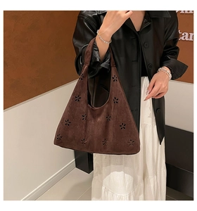 Brown faux suede hobo bag with laser-cut flower details worn with casual attire