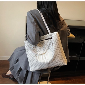 Détail du sac cabas tendance avec motif monogramme M et logo en relief pour le quotidien