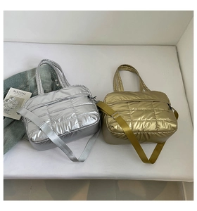 Close-up of metallic quilted tote bags in silver and gold with square stitching texture