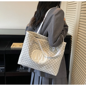 Mannequin portant un grand sac cabas rétro avec imprimé monogramme et logo M