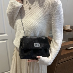 Elegant black velvet crossbody bag with silver chain strap and sparkling diamond clasp