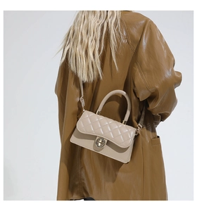 Vue détaillée du sac à bandoulière matelassé beige avec fermoir doré porté par un mannequin