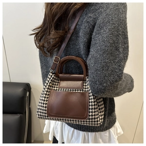 Detail of houndstooth texture and leather trim on a large fashion tote bag for women