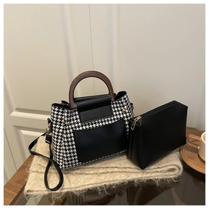 Detail of Boston bag set with houndstooth pattern and elegant wooden top handles