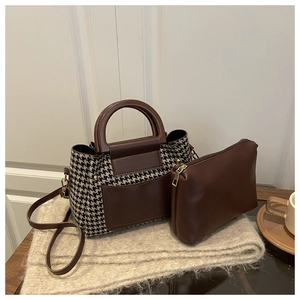 Detail of houndstooth patchwork tote bag set with brown leather accents and small pouch