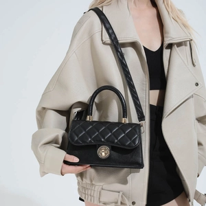 Sac bandoulière élégant en cuir matelassé noir avec fermoir rotatif doré et anse