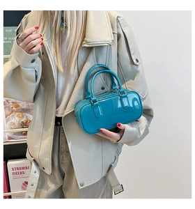 Detail of glossy teal jelly Boston bag with smooth top handles and vibrant finish
