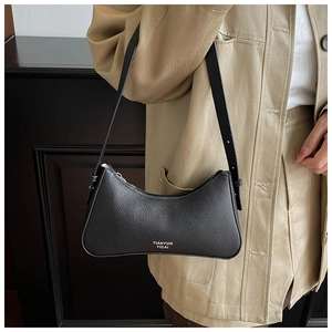 Close-up of black lychee grain leather underarm bag with white lettering and gold zipper