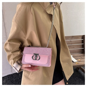 Detailed close-up of pink sequin shoulder bag with silver chain and metal lock buckle