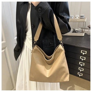 Detail of minimalist khaki hobo bag with litchi texture and gold metal buckle