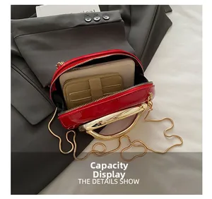 Detail view of red patent leather mini bag showing gold metal handle and internal capacity