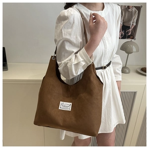 Detail of vintage large capacity dark brown matte shoulder bag with minimalist patch