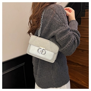 Close-up of silver sequin shoulder bag with metal chain strap and double-ring buckle
