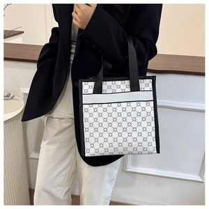 Detail of a large capacity tote bag with black geometric floral pattern and black handles