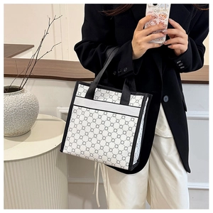 Detailed shot of large capacity polka dot tote bag with black monogram patterns and handles