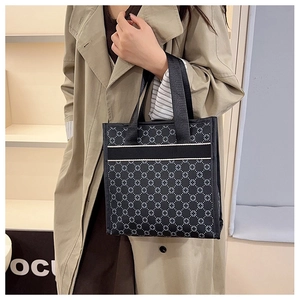 Polka dot floral pattern tote bag being held by a model in a stylish trench coat