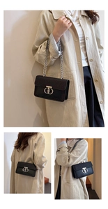 Detail of black sequined flap bag with silver CD buckle and chain strap on trench coat
