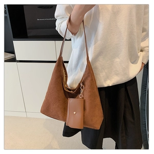 Detail of a brown suede hobo tote bag featuring a matching small pouch and gold hardware