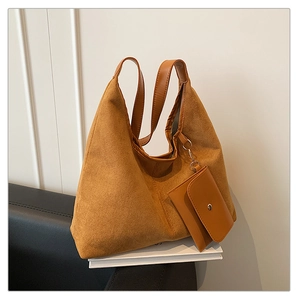 Detailed macro view of brown frosted leather tote bag texture with matching mini coin purse