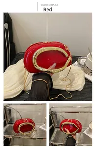 Detail of red patent leather mini bag featuring gold circular handle and metal chain strap