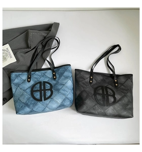 Detailed macro view of quilted diamond patterns and interlocking circular logo on tote bags