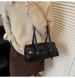 Chic black oil wax leather baguette bag shown on shoulder for a minimalist look