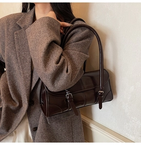 Detail of glossy oil wax leather texture and vintage buckle on brown shoulder bag